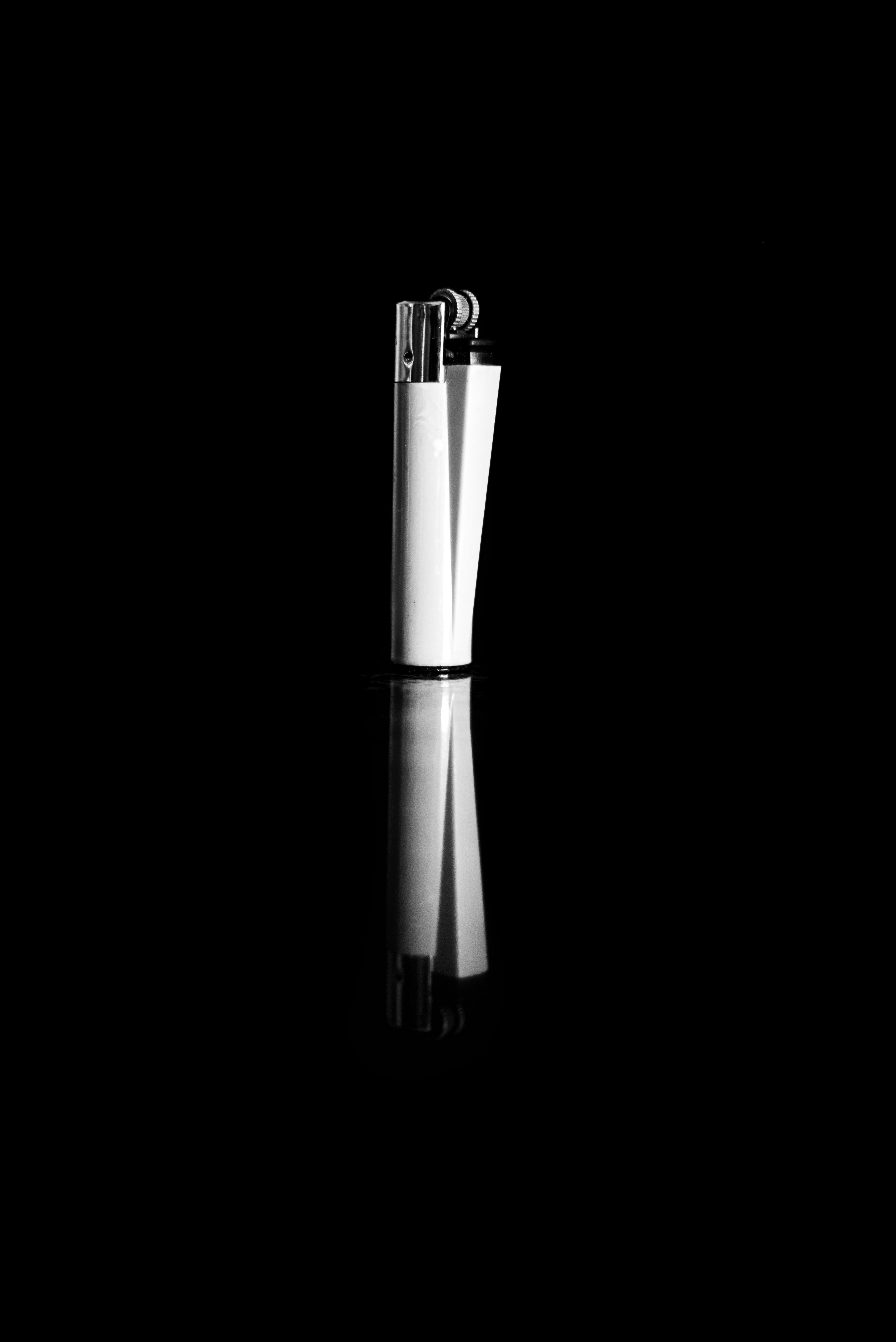 A striking black and white image of a lighter with a reflective surface, capturing simplicity and elegance.