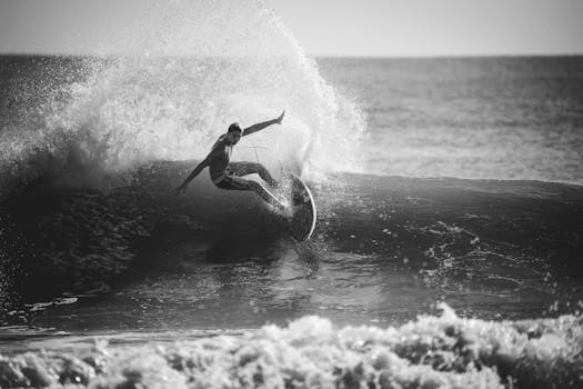 Captivating black and white image of a surfer riding a wave, showcasing skill and dynamic movement.