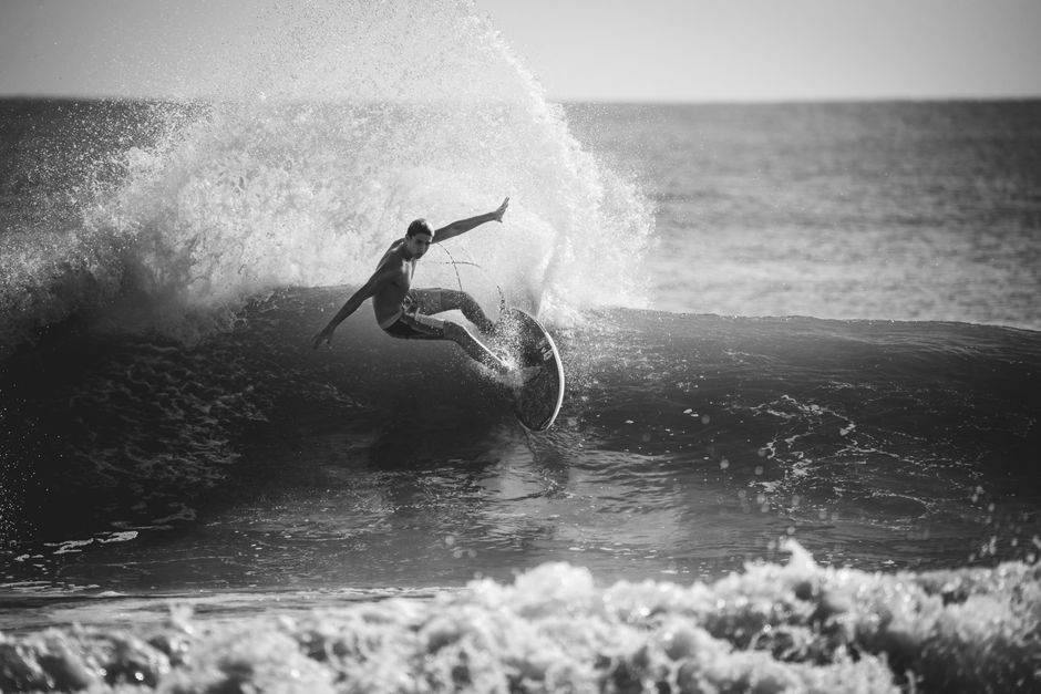 Captivating black and white image of a surfer riding a wave, showcasing skill and dynamic movement.