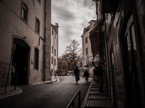 A scenic view of a narrow street with historical buildings and pedestrians, capturing the essence of an old city center.