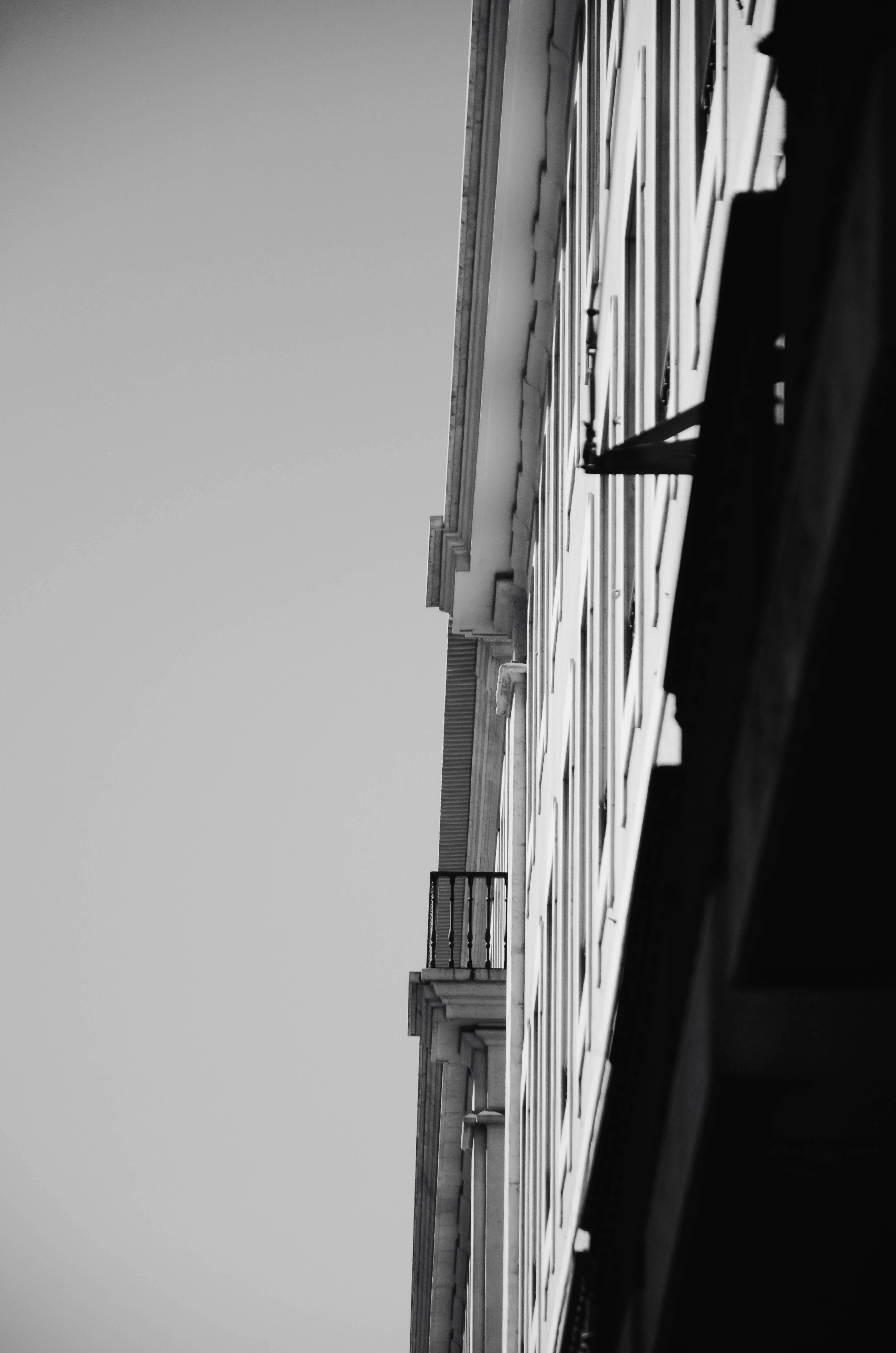 Gratis Ángulo dramático de la fachada de un edificio en blanco y negro, que muestra la simetría arquitectónica. Foto de stock