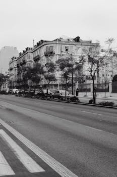 Black and white photo of an empty street with historic buildings.