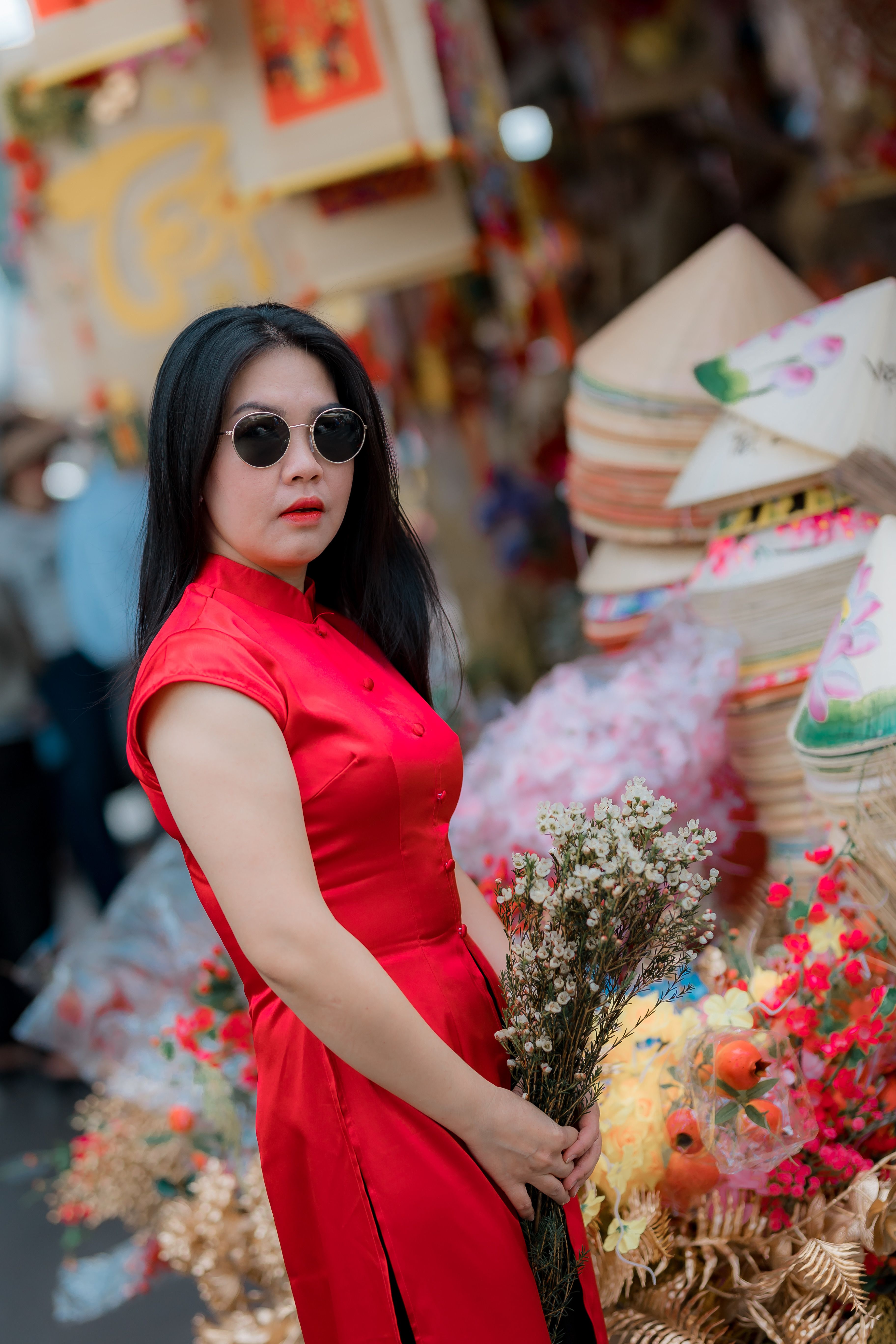 Elegant Woman in Red Dress Holding Flowers · Free Stock Photo
