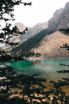 Serene canoeing experience on emerald waters surrounded by majestic rocky mountains in Alberta, Canada.