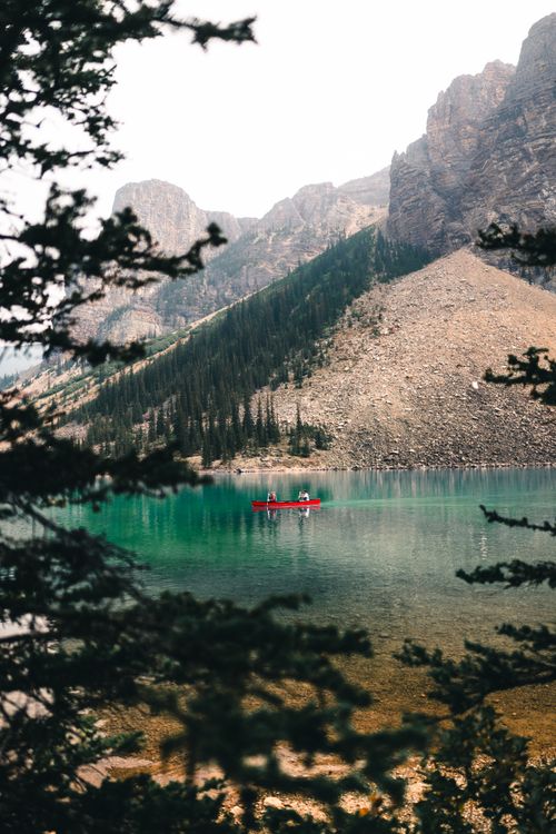 Free Serene canoeing experience on emerald waters surrounded by majestic rocky mountains in Alberta, Canada. Stock Photo