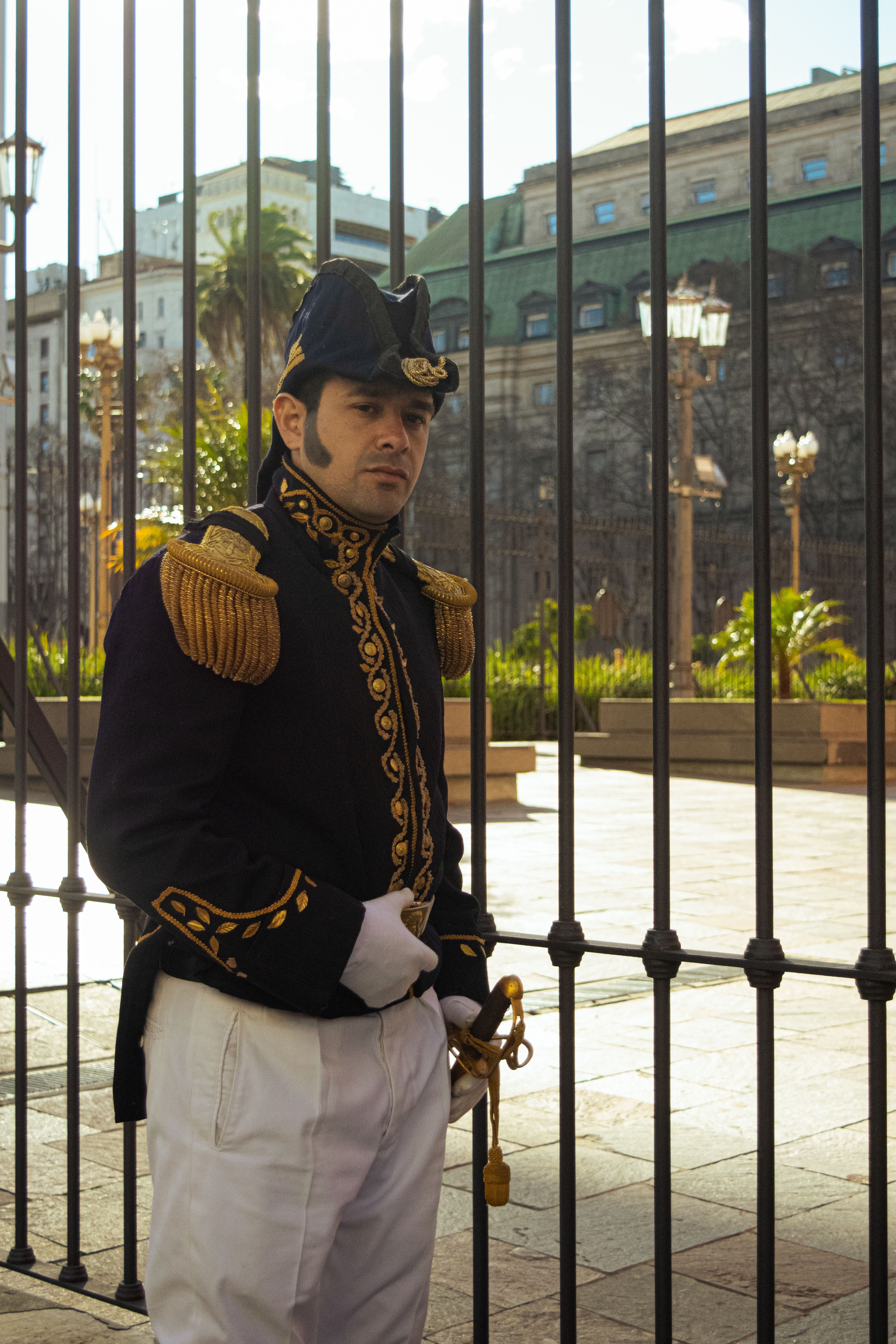A traditional Argentinian guard stands beside a metal gate in Buenos Aires.
