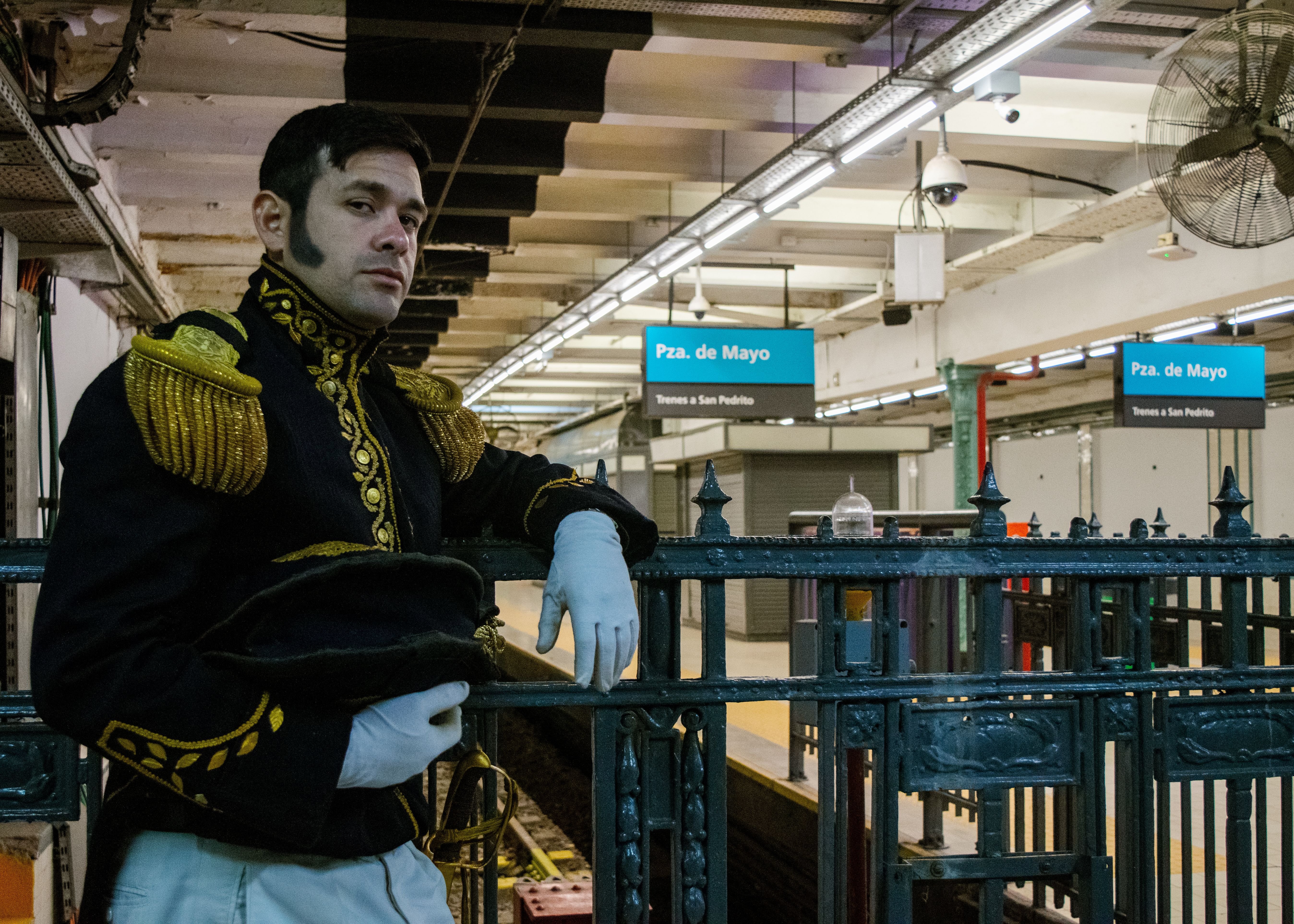 A man in a historic uniform stands at the Plaza de Mayo subway station in Buenos Aires.
