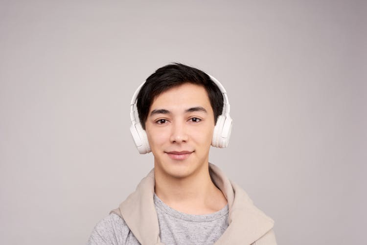 Portrait Photography Of Man Wearing White Wireless Headphones