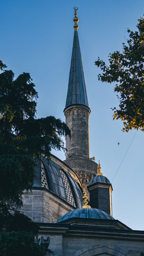 Free Stunning mosque minaret surrounded by trees at sunset, showcasing architectural beauty and natural harmony. Stock Photo