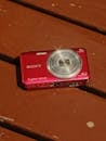 Red Digital Camera on Wooden Surface