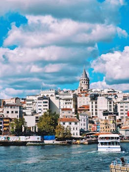 Explore the iconic Galata Tower amidst the vibrant Istanbul skyline on a sunny day.