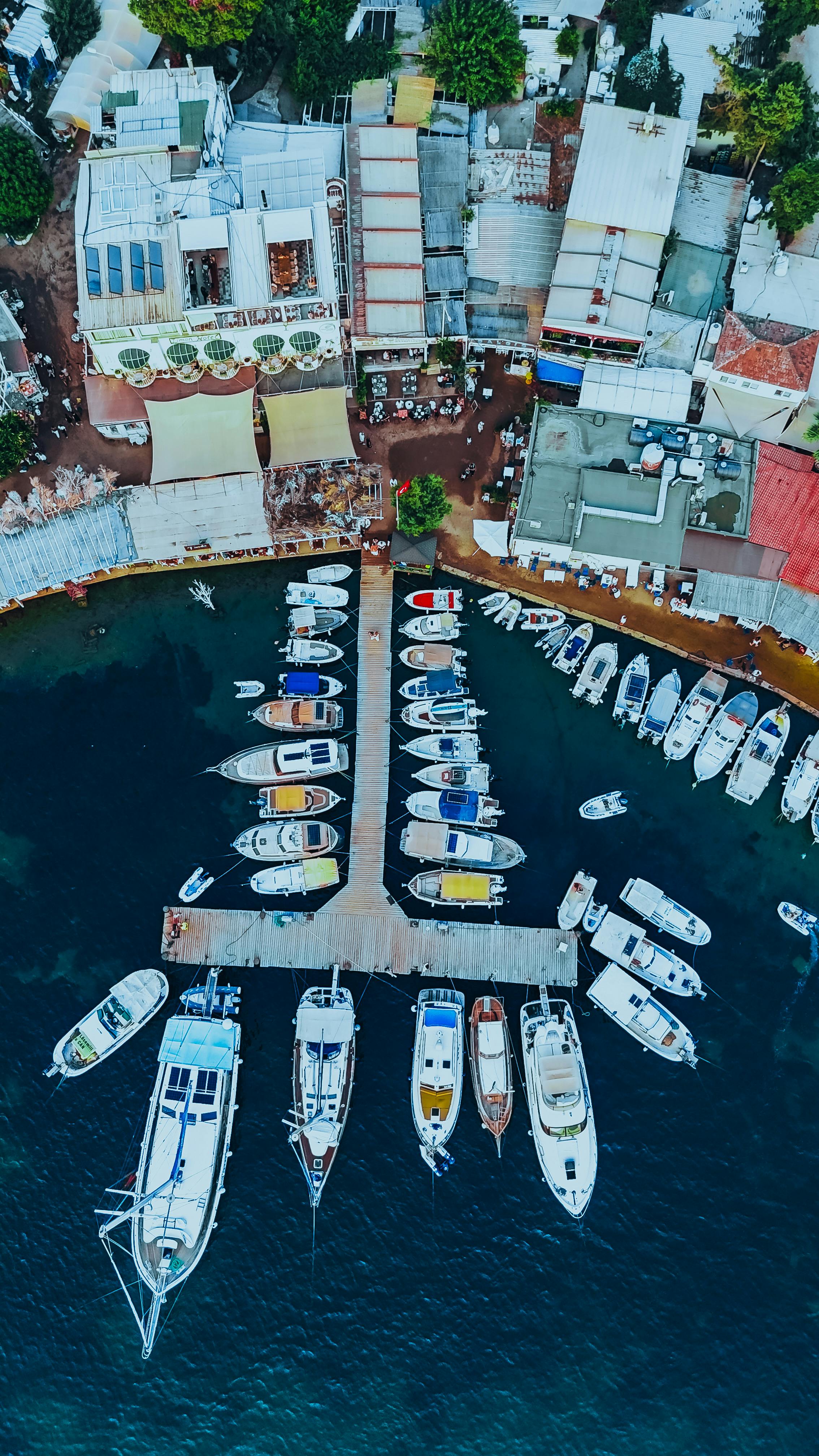 grátis Vista colorida da marina com barcos atracados e estruturas urbanas próximas, vibrantes e dinâmicas. Foto profissional