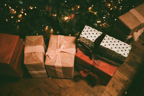 Ассорти из подарочных коробок на полу возле елки