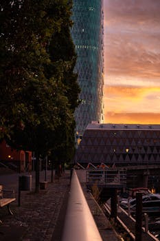 Stunning sunrise view of a skyscraper by the river in Frankfurt, Germany.