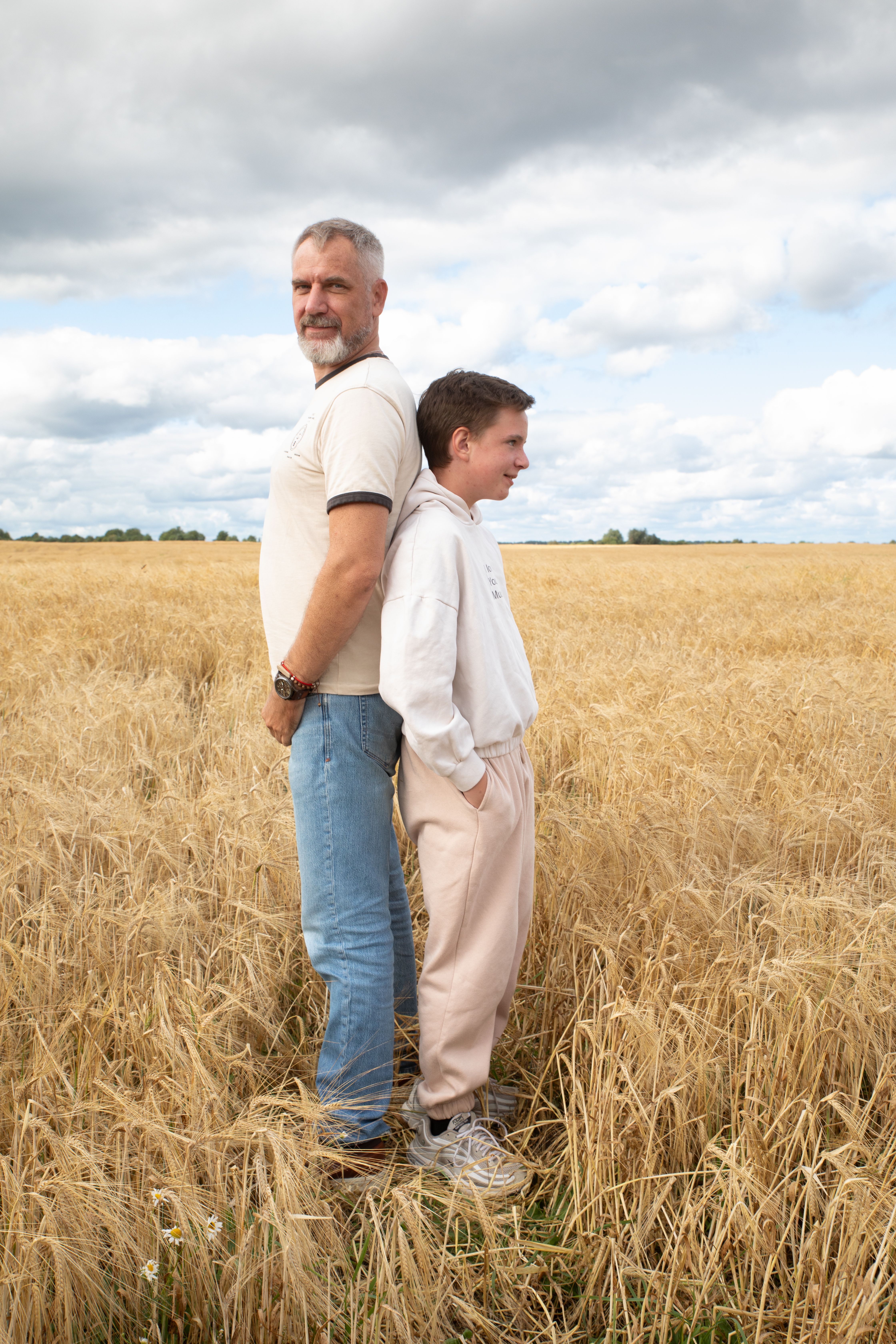 Father and Son Standing Back to Back in Wheat Field · Free Stock Photo