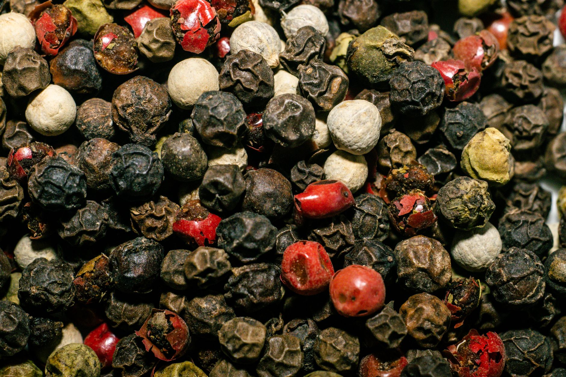 Freshly ground white pepper being sprinkled over creamy soup