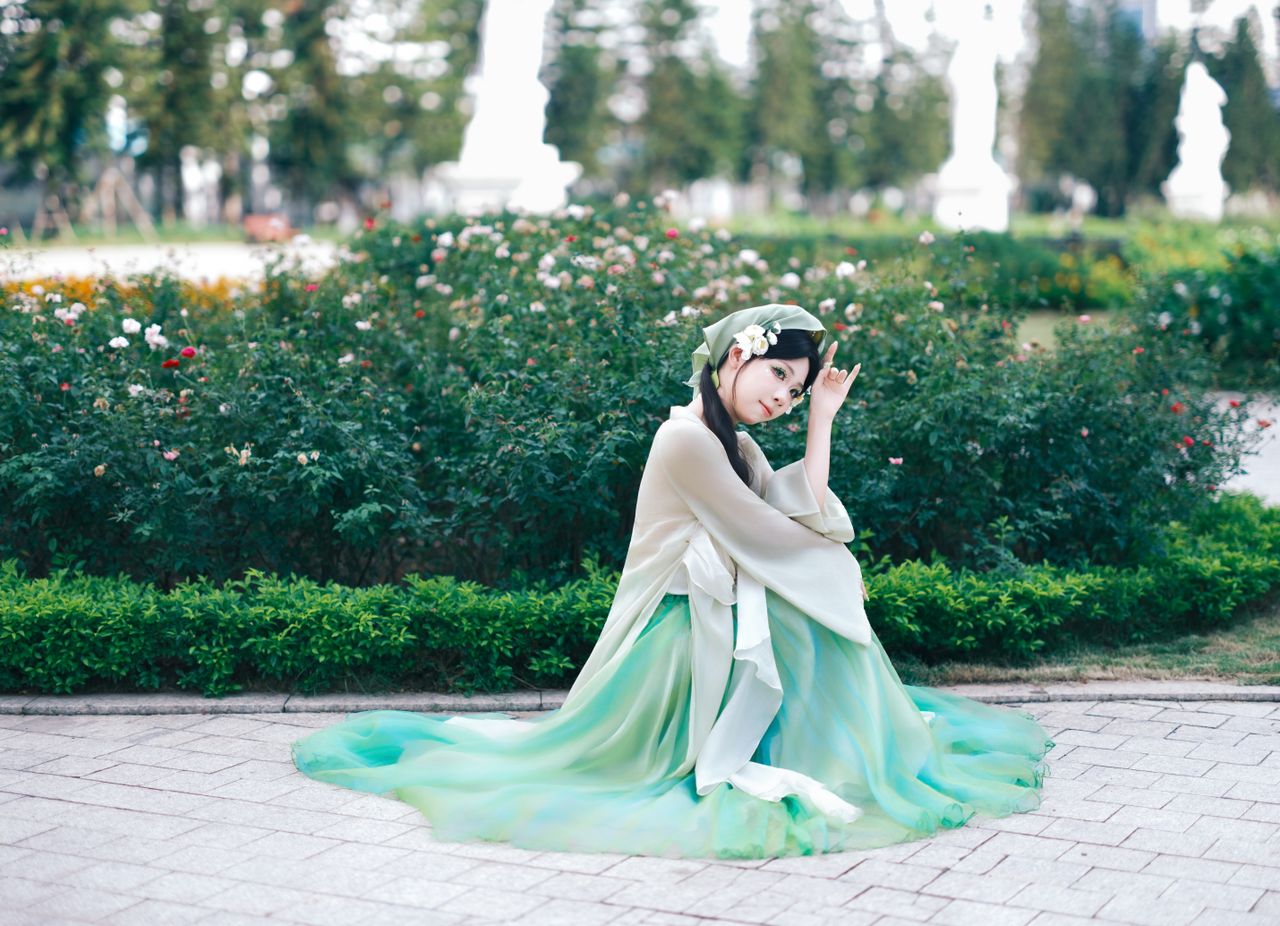 woman in traditional dress kneeling in a beautiful garden captured wit