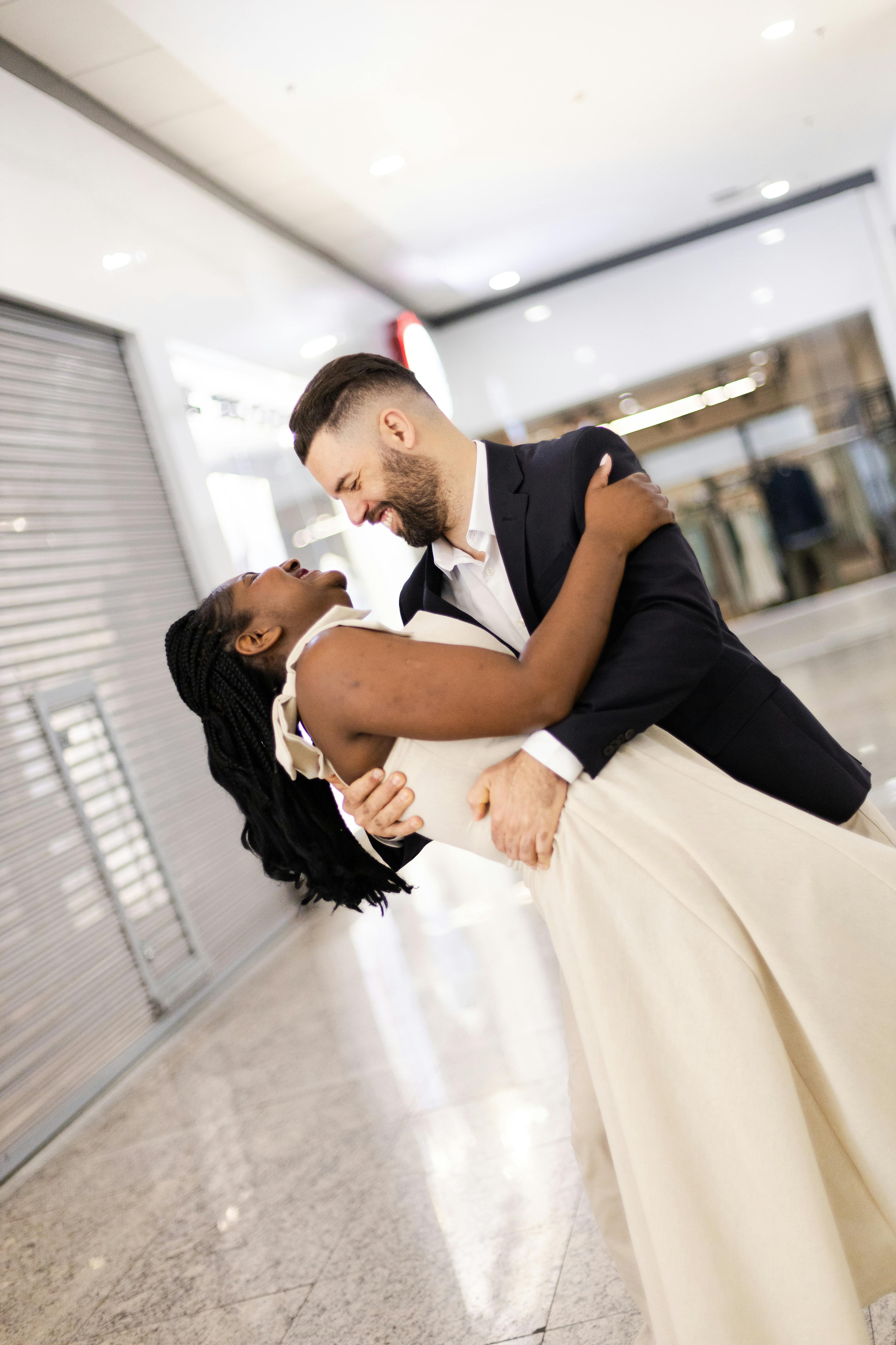 A joyful couple embracing and dancing indoors, capturing a loving moment.