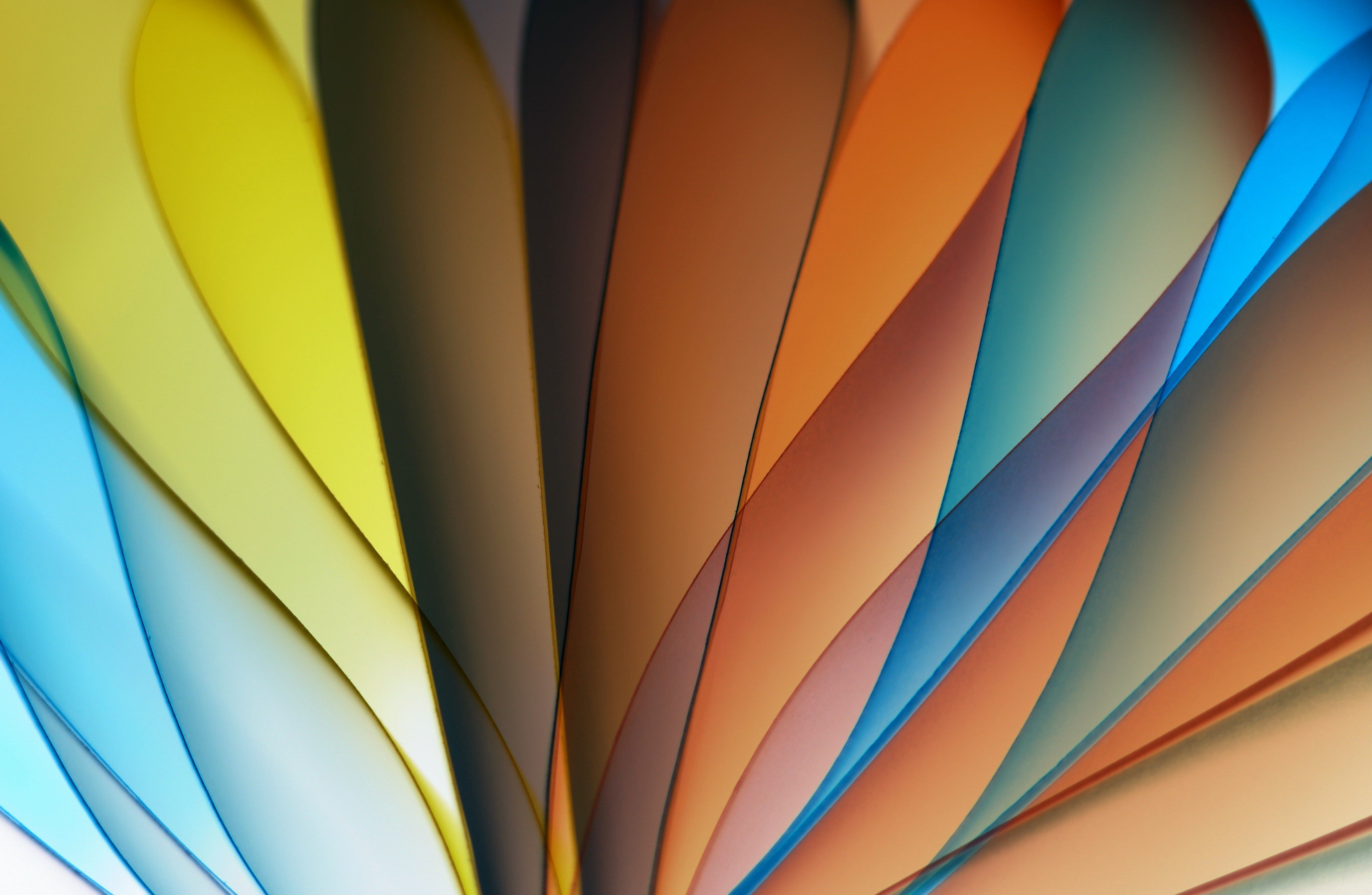 Dynamic abstract image showcasing colorful paper fan design in vibrant hues of yellow, orange, and blue.