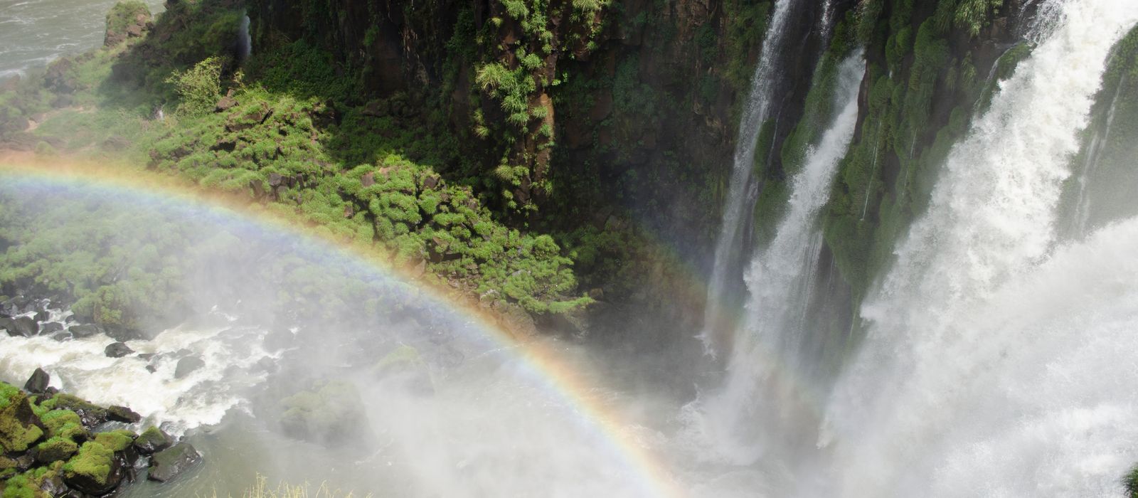 Stunning view of a rainbow against the backdrop of Iguazu Falls and lush greenery. — flights from Buenos Aires to Iguazu