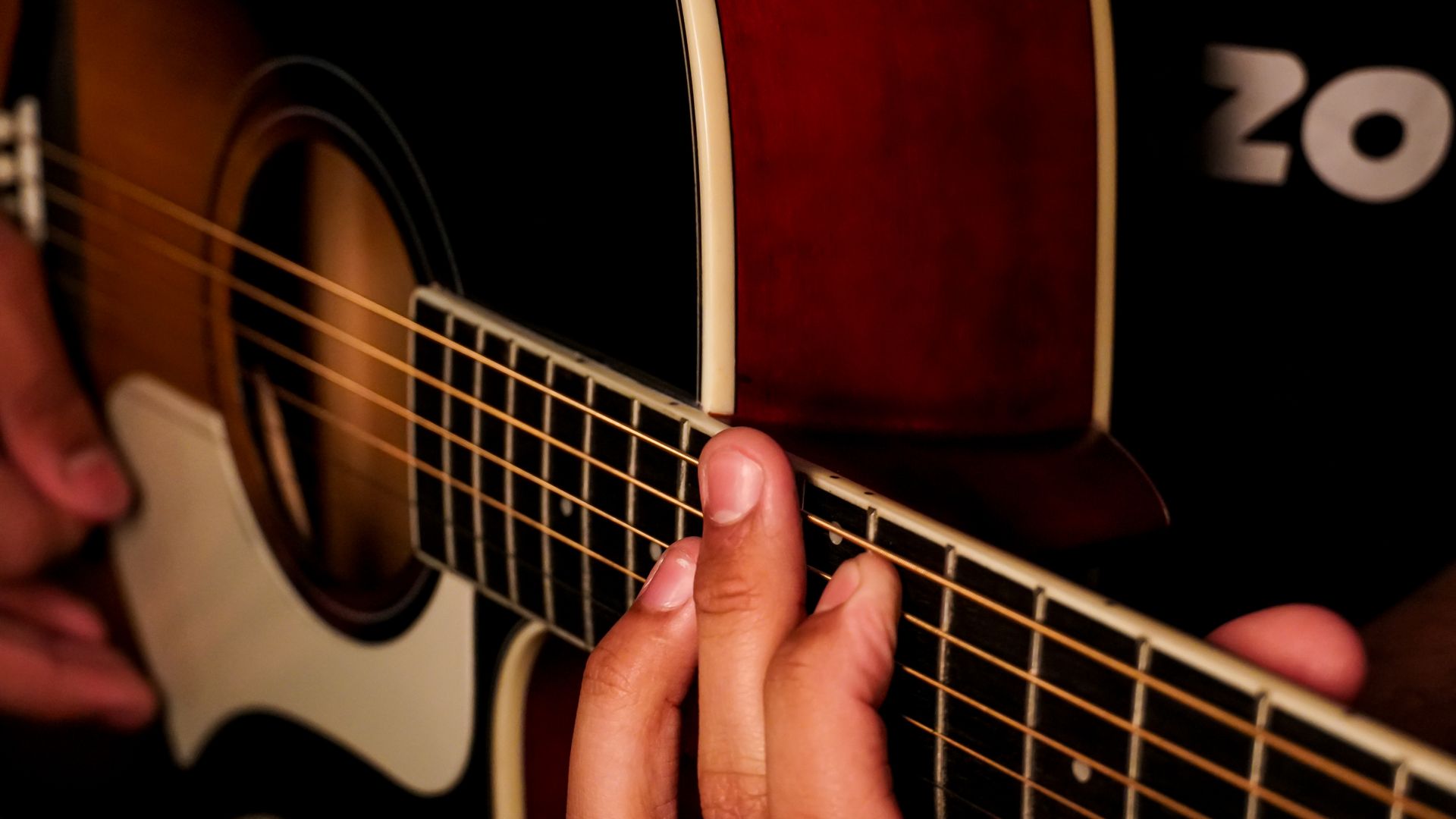 Modafinil for Musicians on Tour: Maximising Energy and Focus Detailed close-up of hands playing an acoustic guitar, emphasizing strings and finger placement — modafinil for musicians on tour