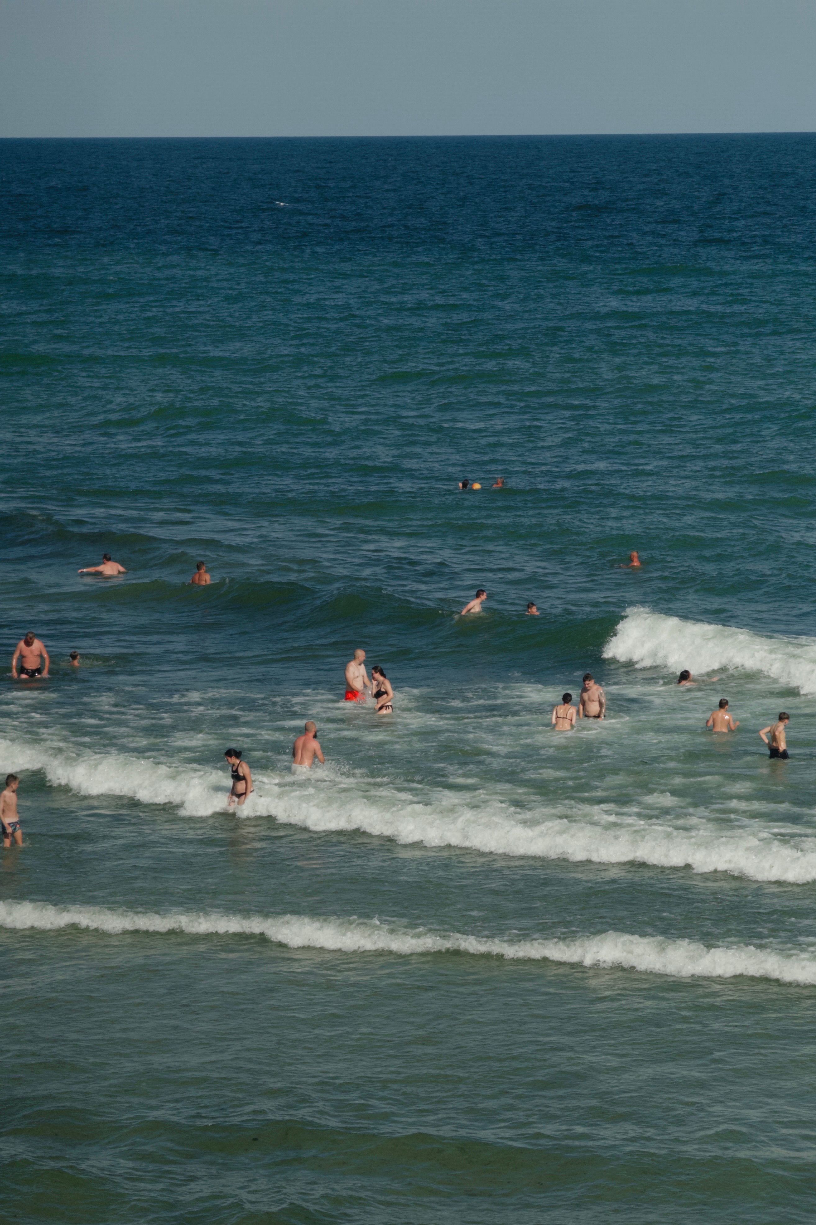 Group enjoying a sunny day swimming in the ocean's waves.