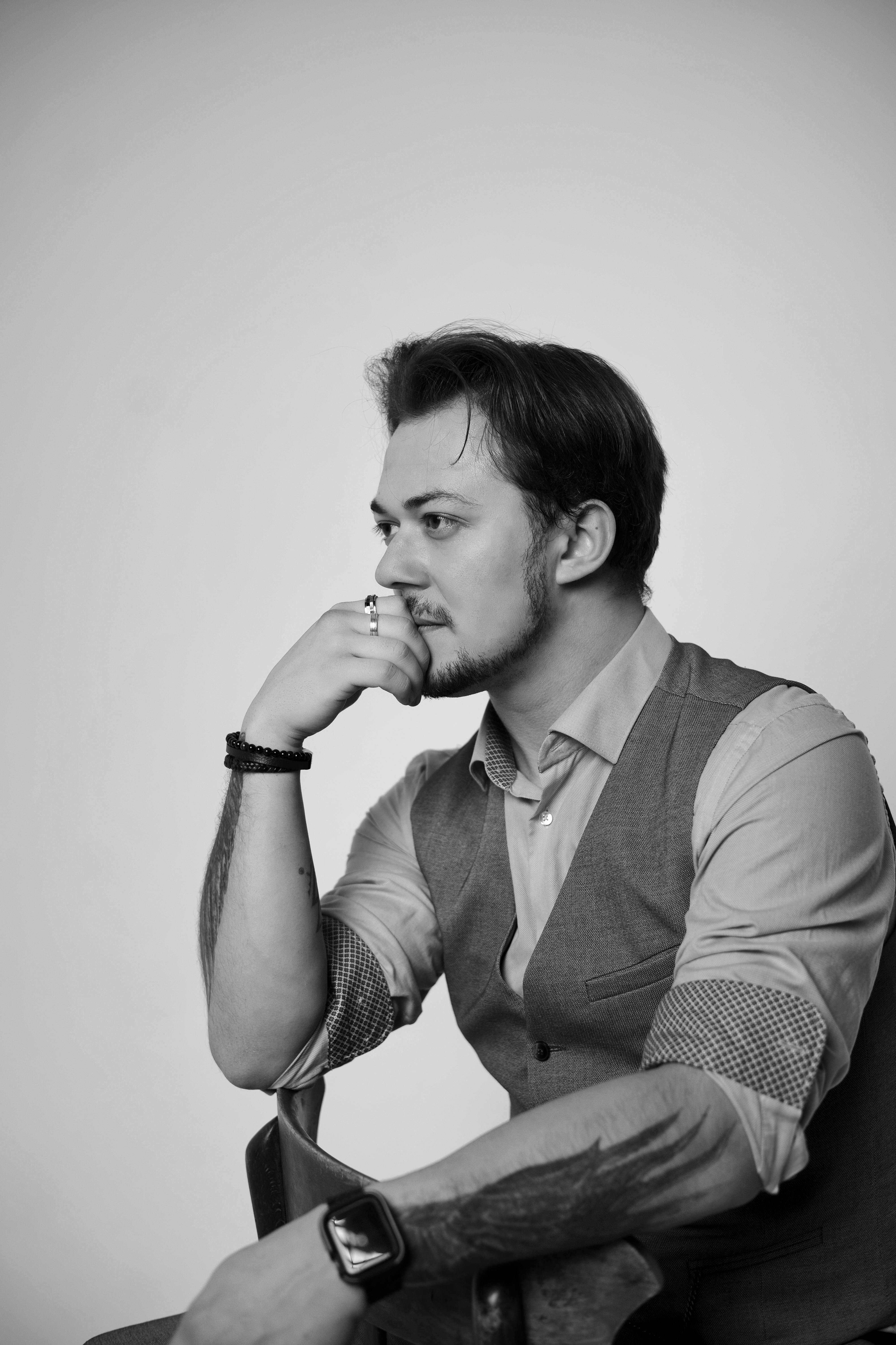 Free Black and white portrait of a young man with thoughtful expression, in professional attire. Stock Photo