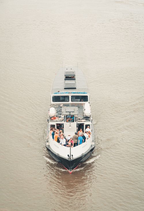 Free High angle modern vessel with tourists on deck floating on muddy river water in daylight Stock Photo