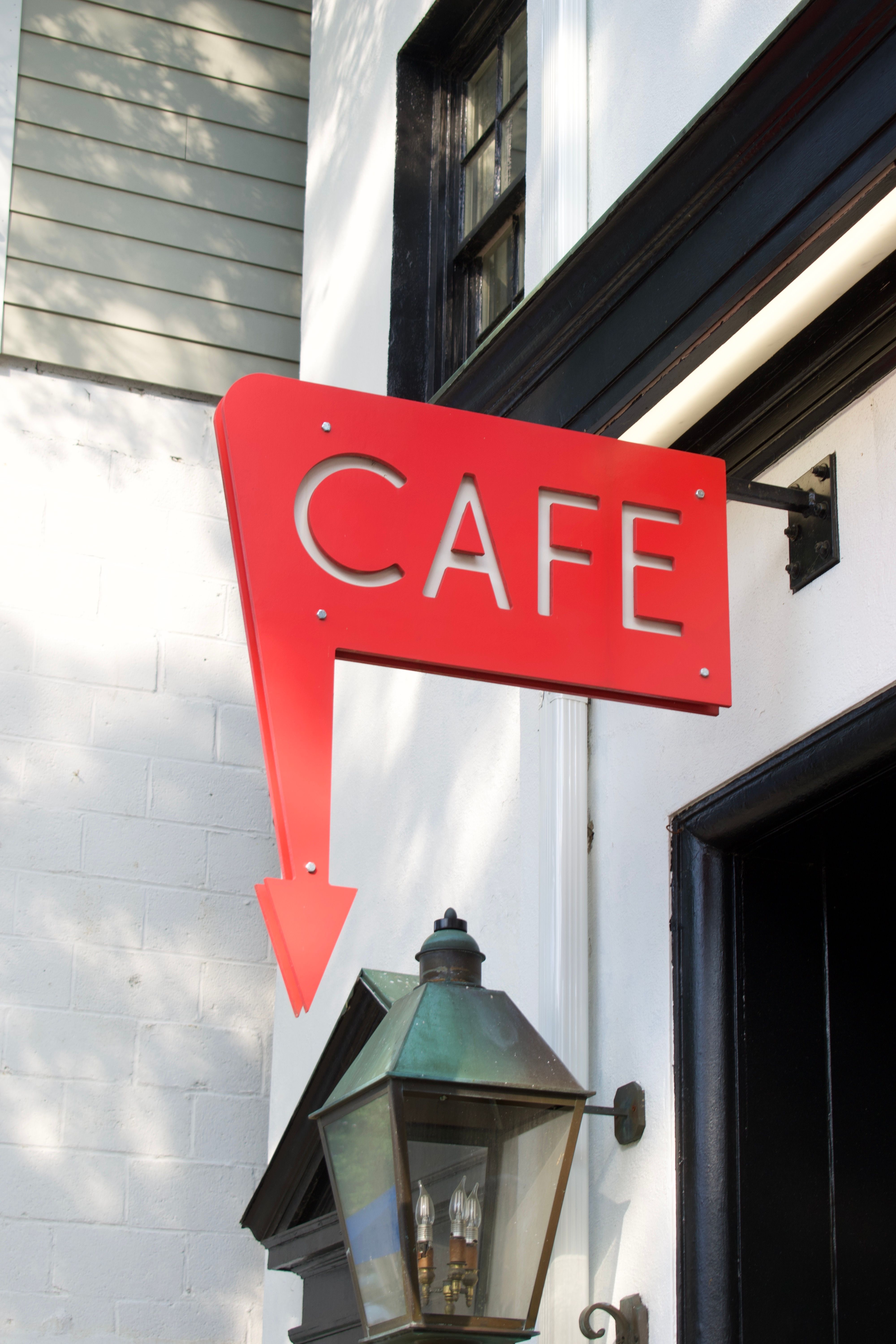 Red Cafe Sign with Arrow in Urban Setting · Free Stock Photo
