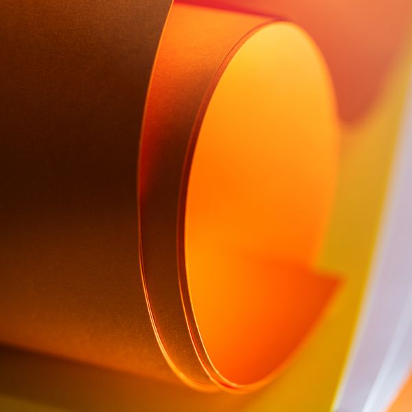 Curled warm-lit paper study — Jakub Zerdzicki on Pexels