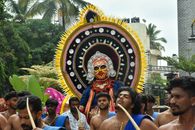 Men in traditional attire celebrate a cultural festival parade in Karnataka with vibrant costumes and ceremonial accessories.