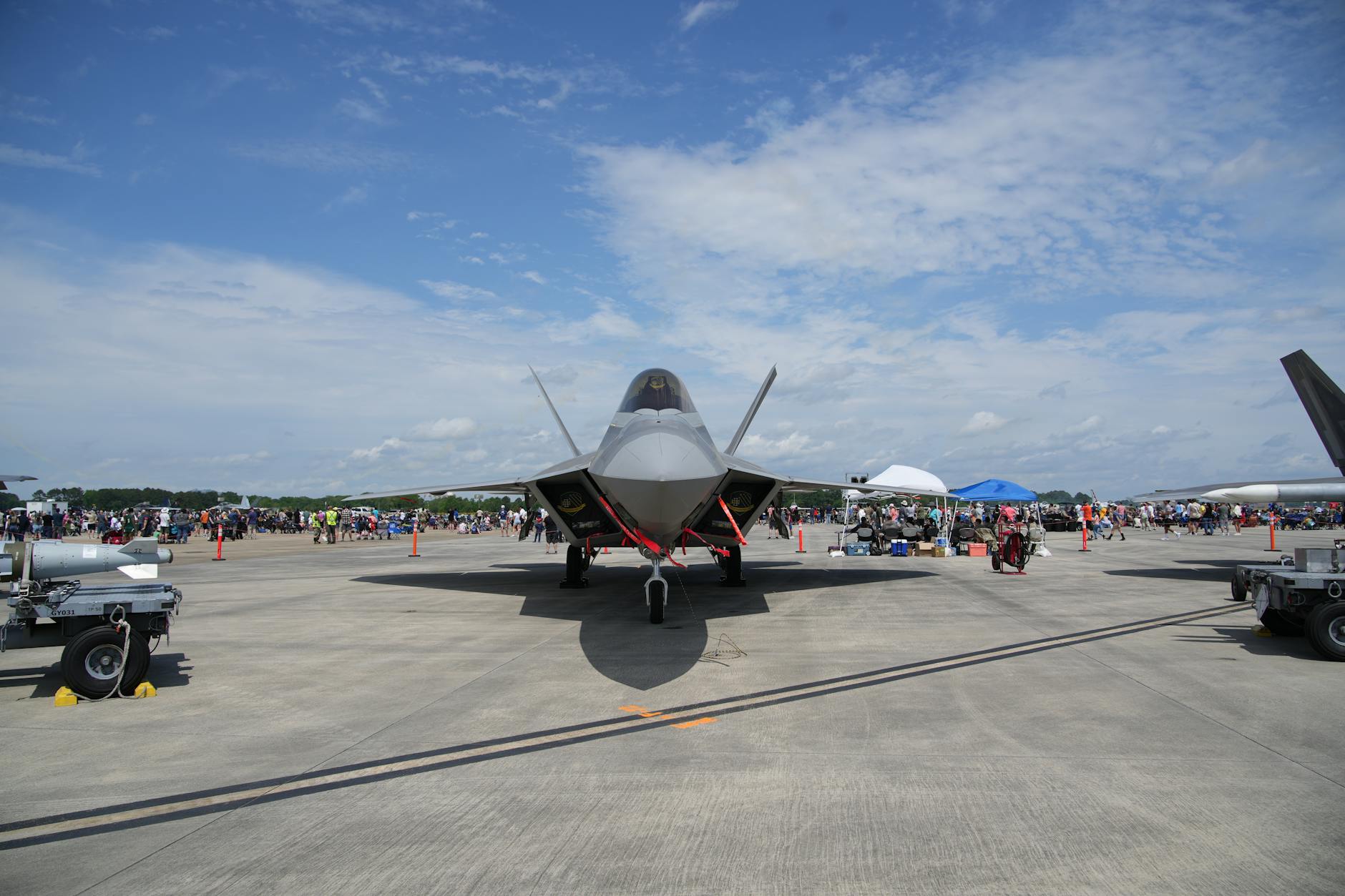F-22 Raptor displayed at Hampton airshow. Clear sky and crowd in background.
