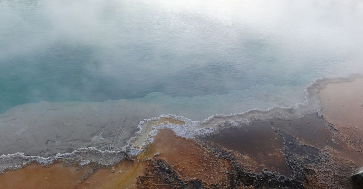 A mesmerizing view of a steaming geothermal pool in Yellowstone National Park, USA.