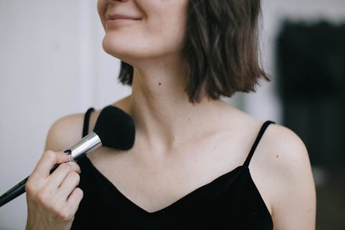 Woman Wearing Black Spaghetti Strap Top Using Makeup Brush