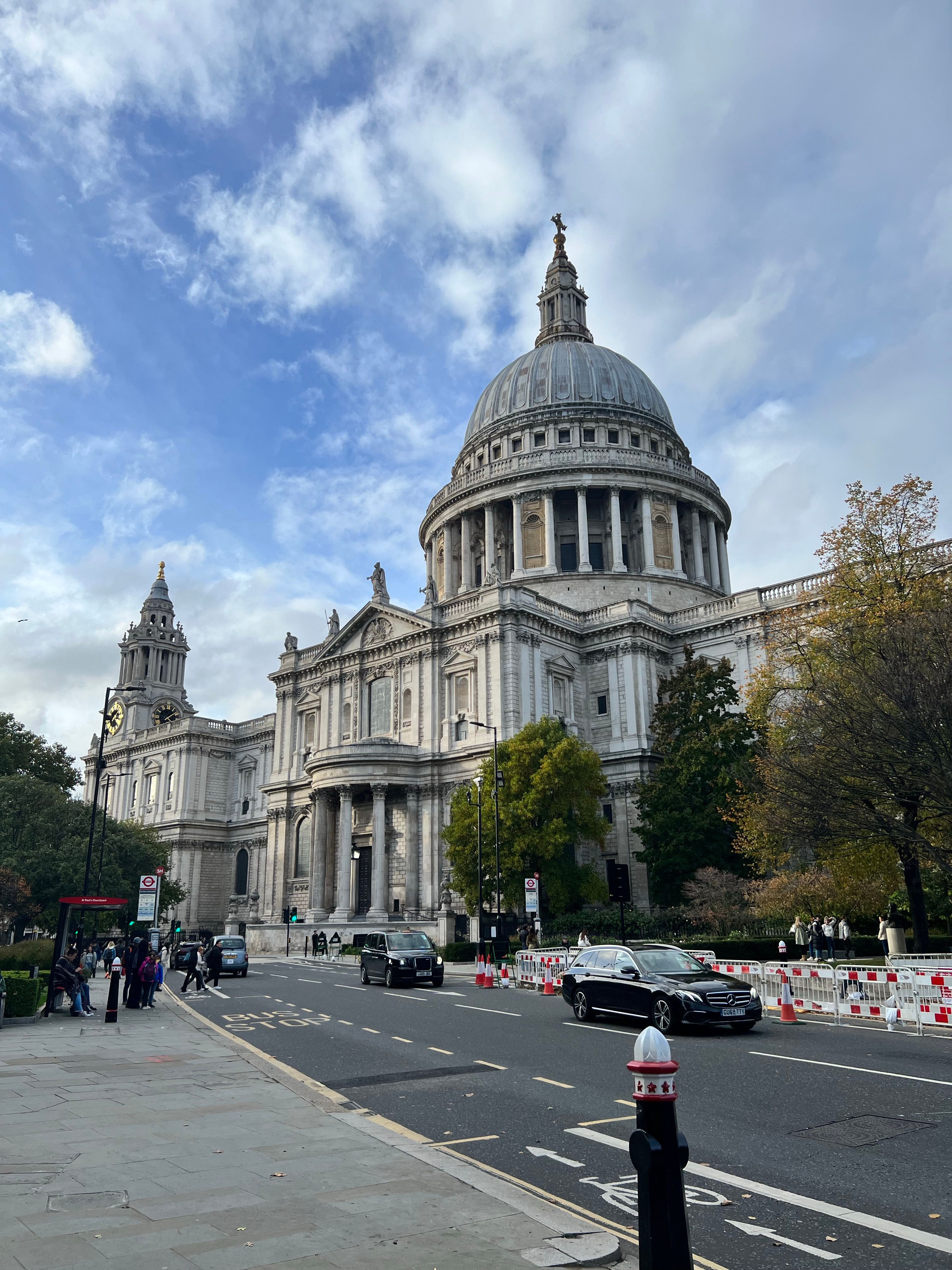 Street view of St. Paul's Cathedral, London, with a lively urban scene.