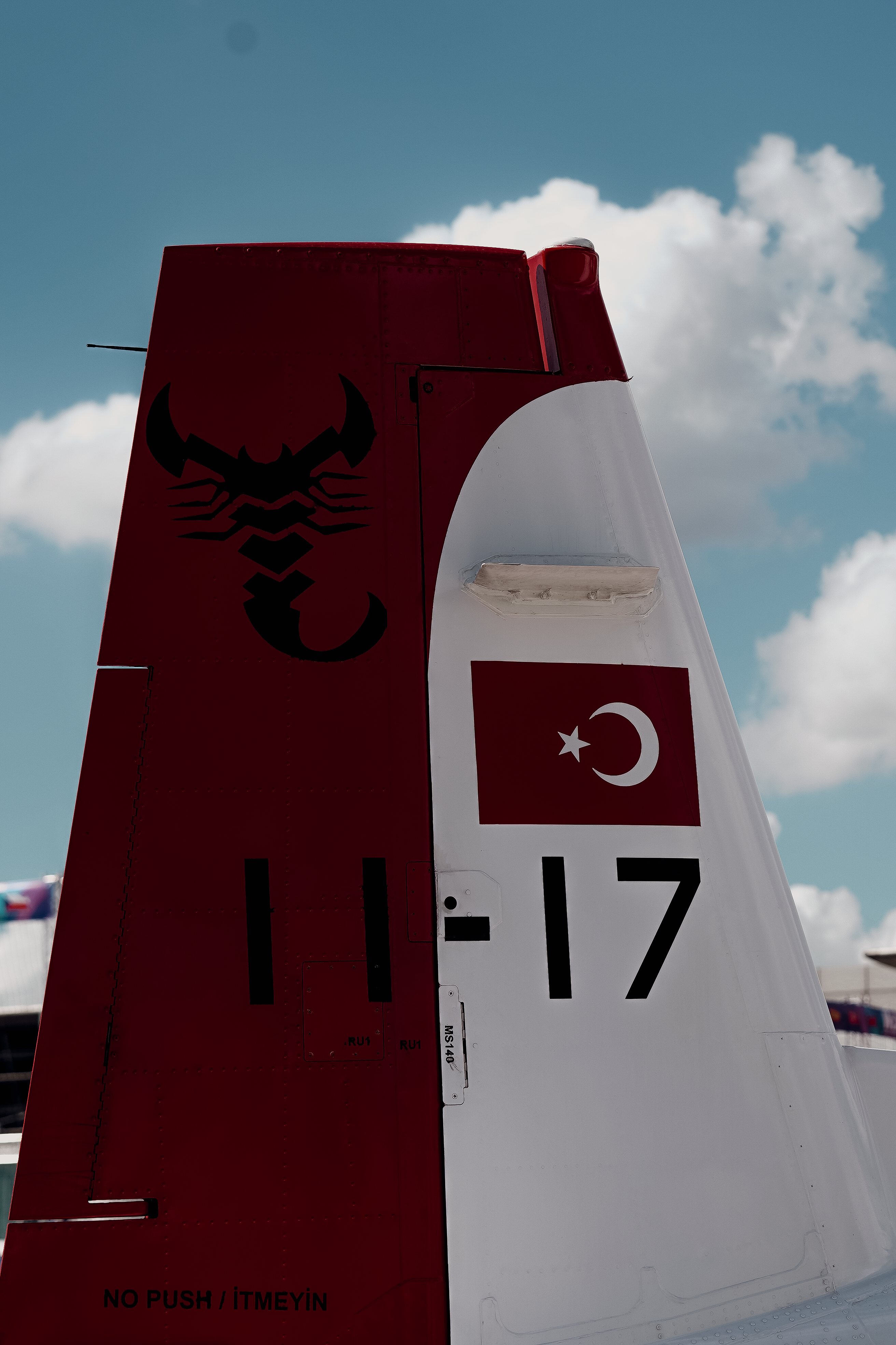 Close-up of a Turkish aircraft tail featuring the national flag and emblem under a blue sky.