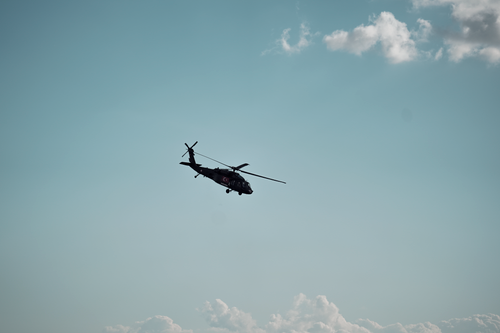 Free Helicopter flying against a clear blue sky with scattered clouds, offering a sense of freedom and adventure. Stock Photo