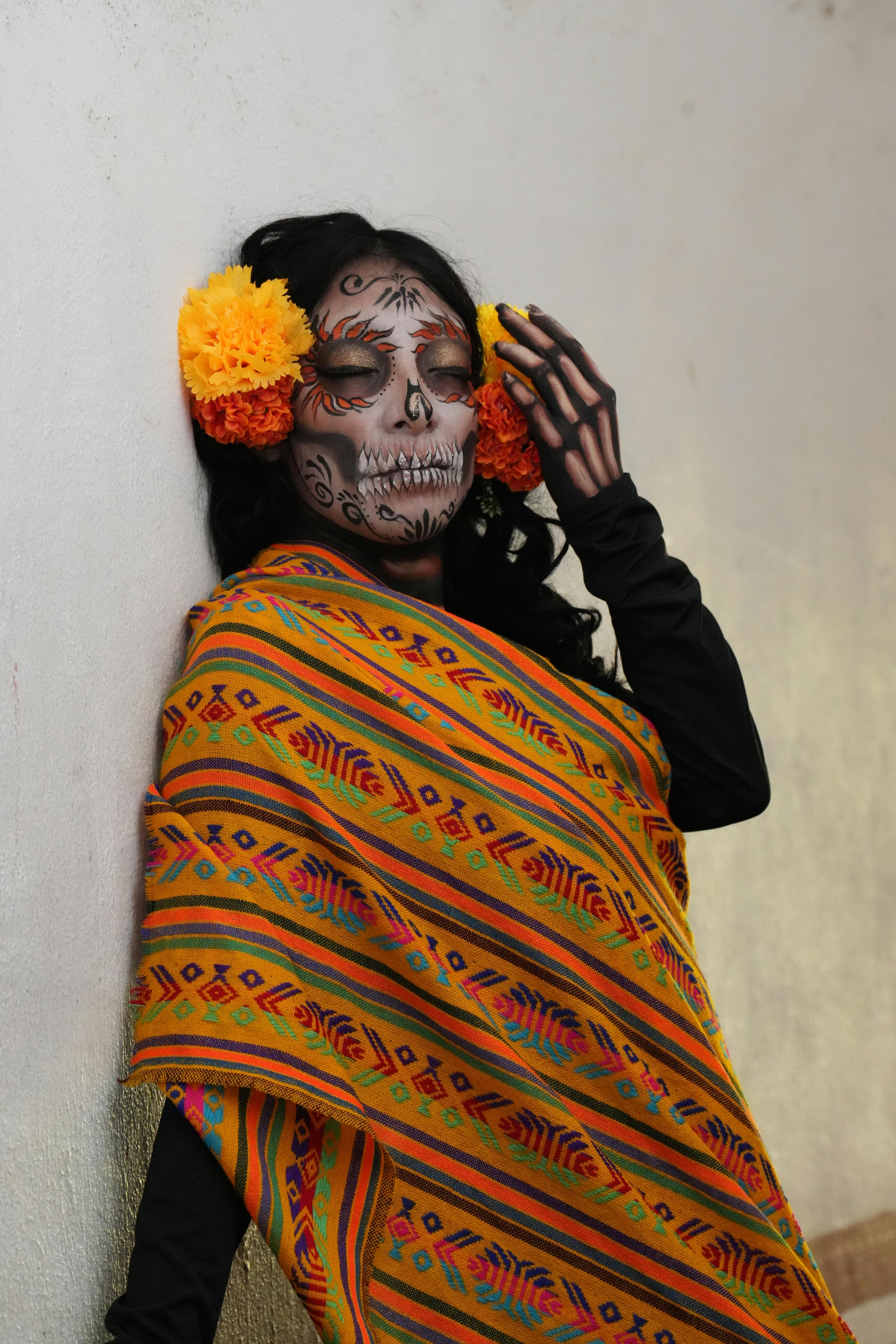 Free A woman with Day of the Dead makeup and vibrant shawl poses indoors. Stock Photo