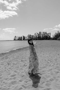 Black and white portrait of a woman in a summer dress on Sturgeon Bay beach, Wisconsin.