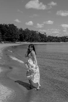 Captivating black and white portrait of a woman in a flowing dress on the beach at Sturgeon Bay, Wisconsin.