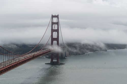Free Aerial view of the Golden Gate Bridge enveloped in fog over San Francisco Bay. Stock Photo