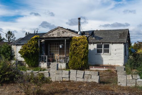 Free Old, dilapidated rural house with overgrown plants and a forgotten atmosphere. Stock Photo