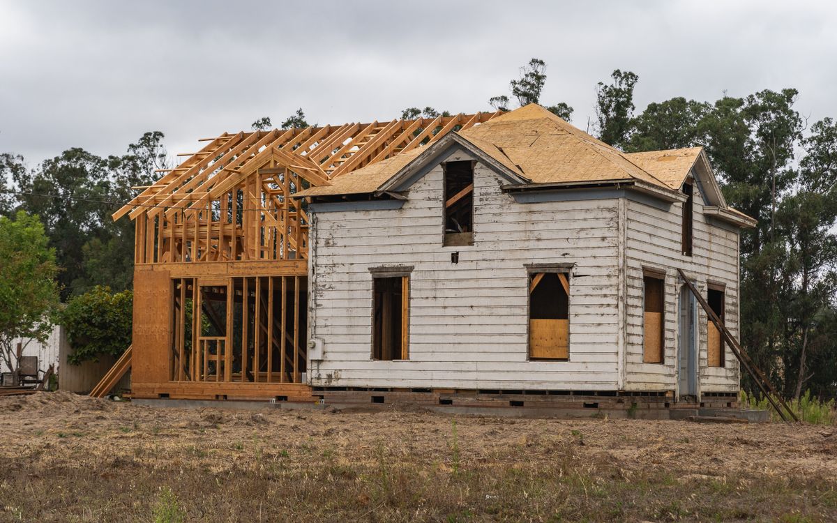 Image of an old house under renovation with new wooden frame structure.