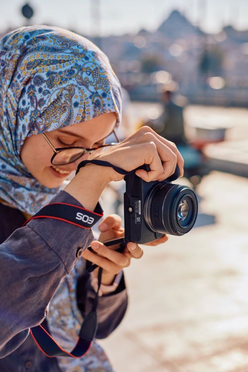 Free A young woman capturing moments with her camera in sunny İstanbul. Stock Photo