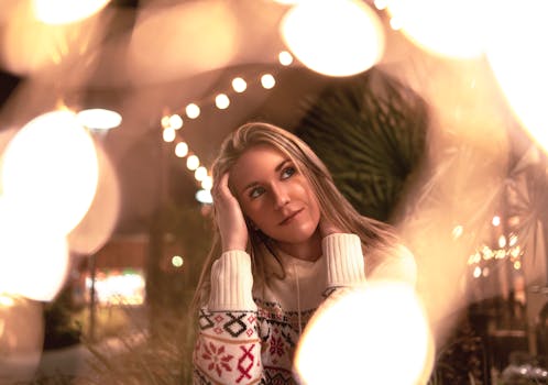 一位年轻女子在节日灯光和冬日氛围的包围中，享受着舒适的夜晚