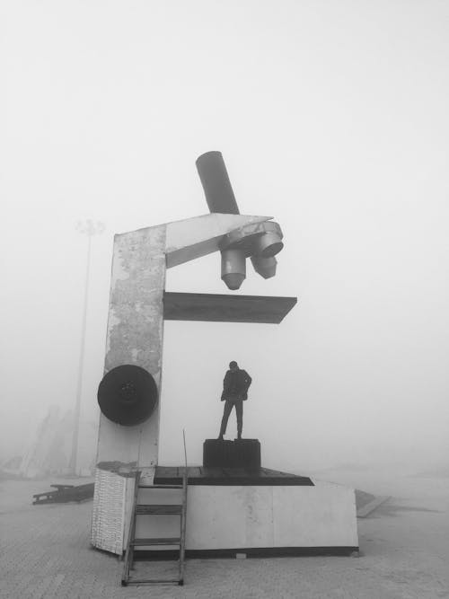 Free Grayscale Photography of Person Standing on Big Microscope Stock Photo