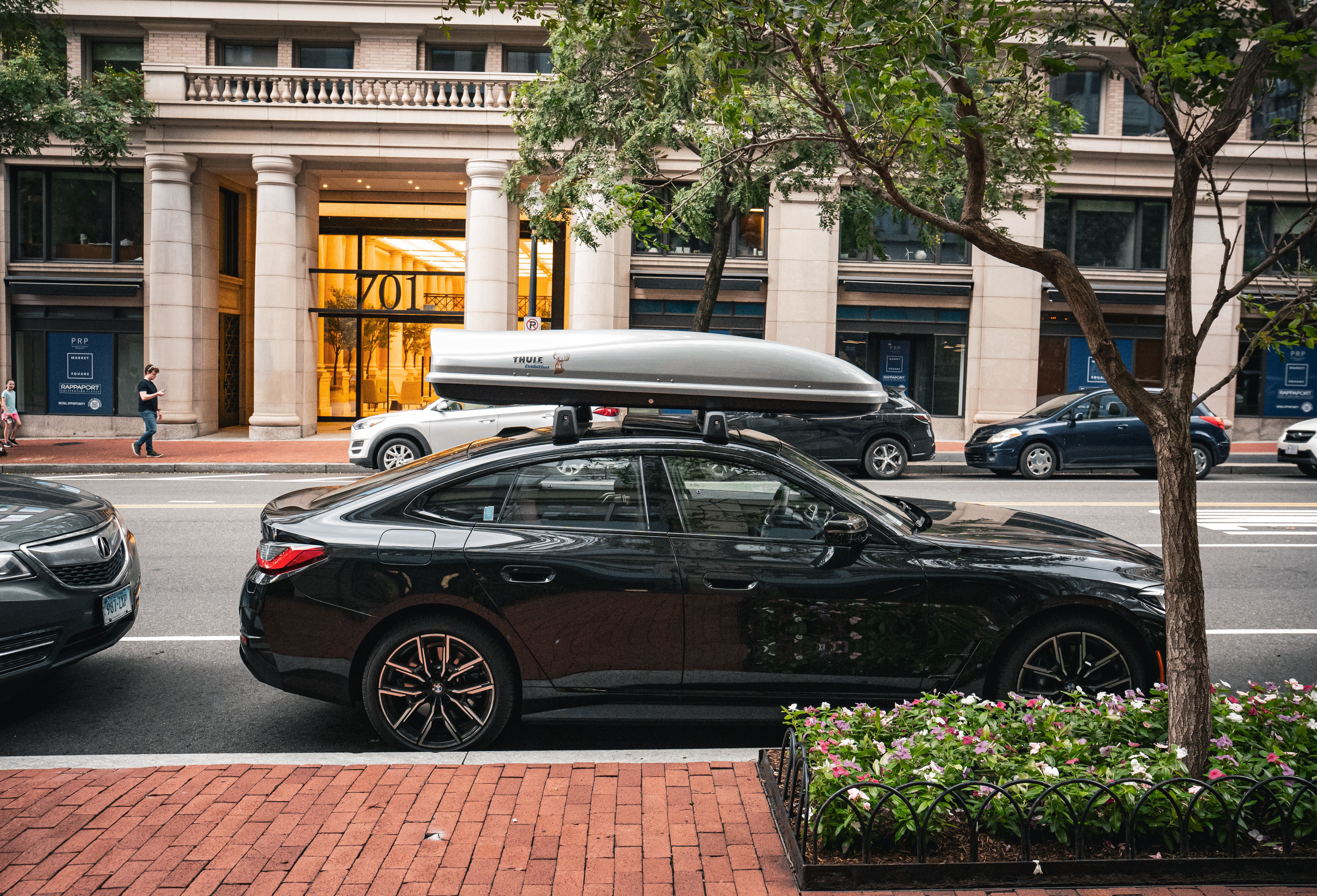 Sleek Black Sedan with Rooftop Cargo Box in Urban Setting · Free Stock ...
