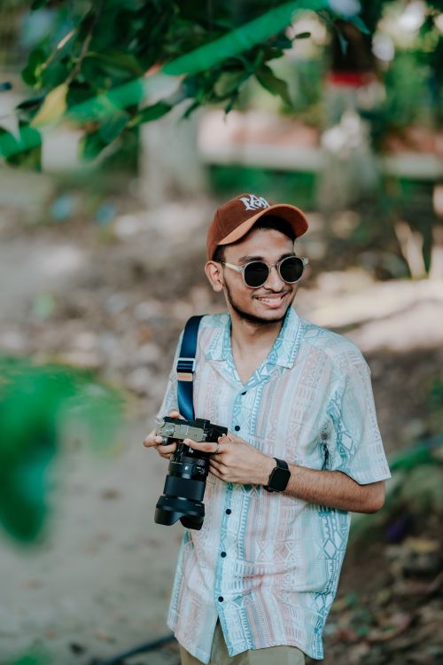 Free Casual young adult with camera enjoys an outdoor photography session. Stock Photo