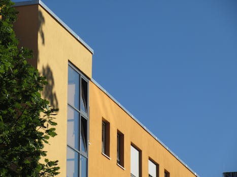 Angle view of a yellow building with windows against a bright clear blue sky.