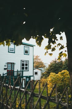 A quaint white house surrounded by vibrant garden in springtime.